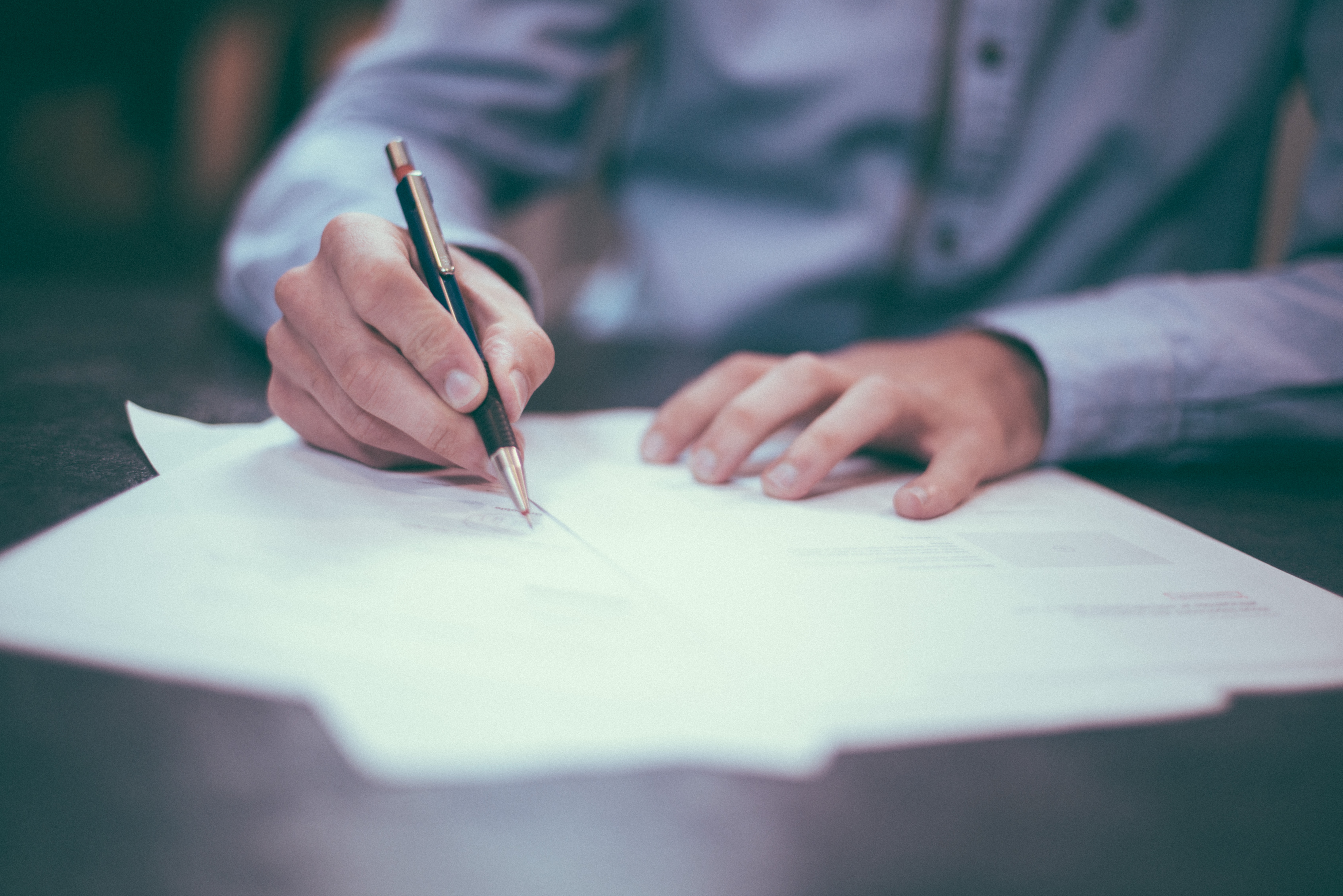 A person writing notes at a table.