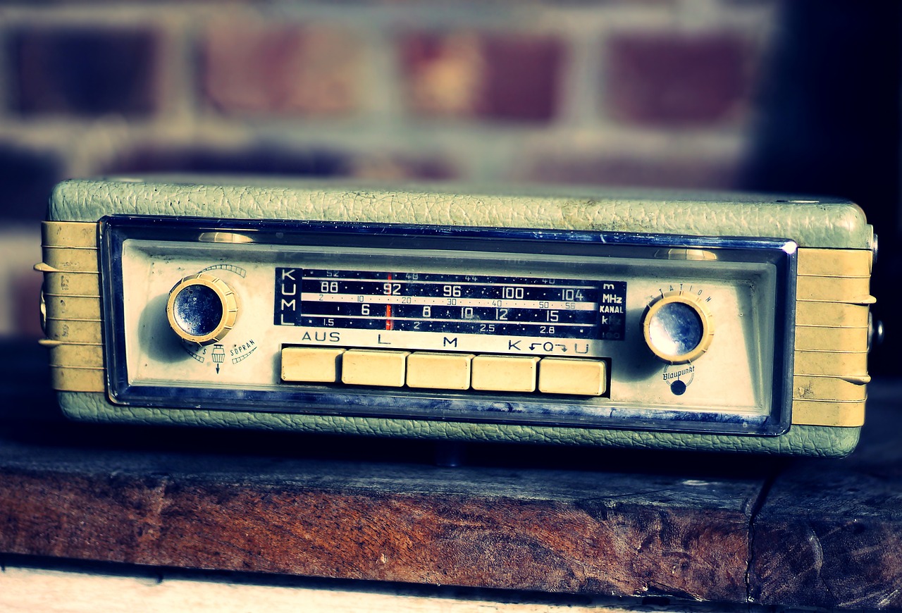 An old car radio, with dials on either side. The radio is nestled on top of a wall.