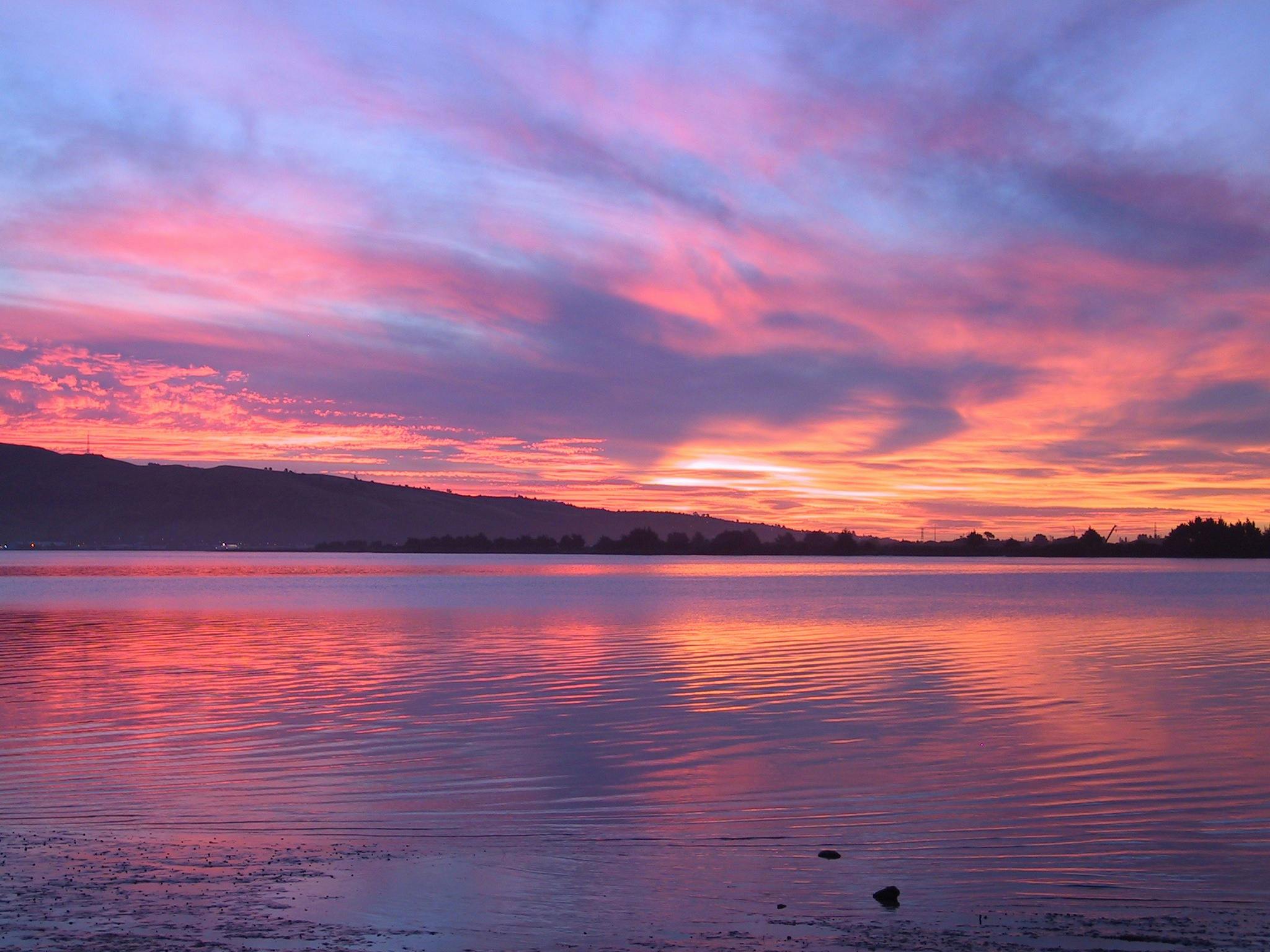 A sunset reflected over a lake.