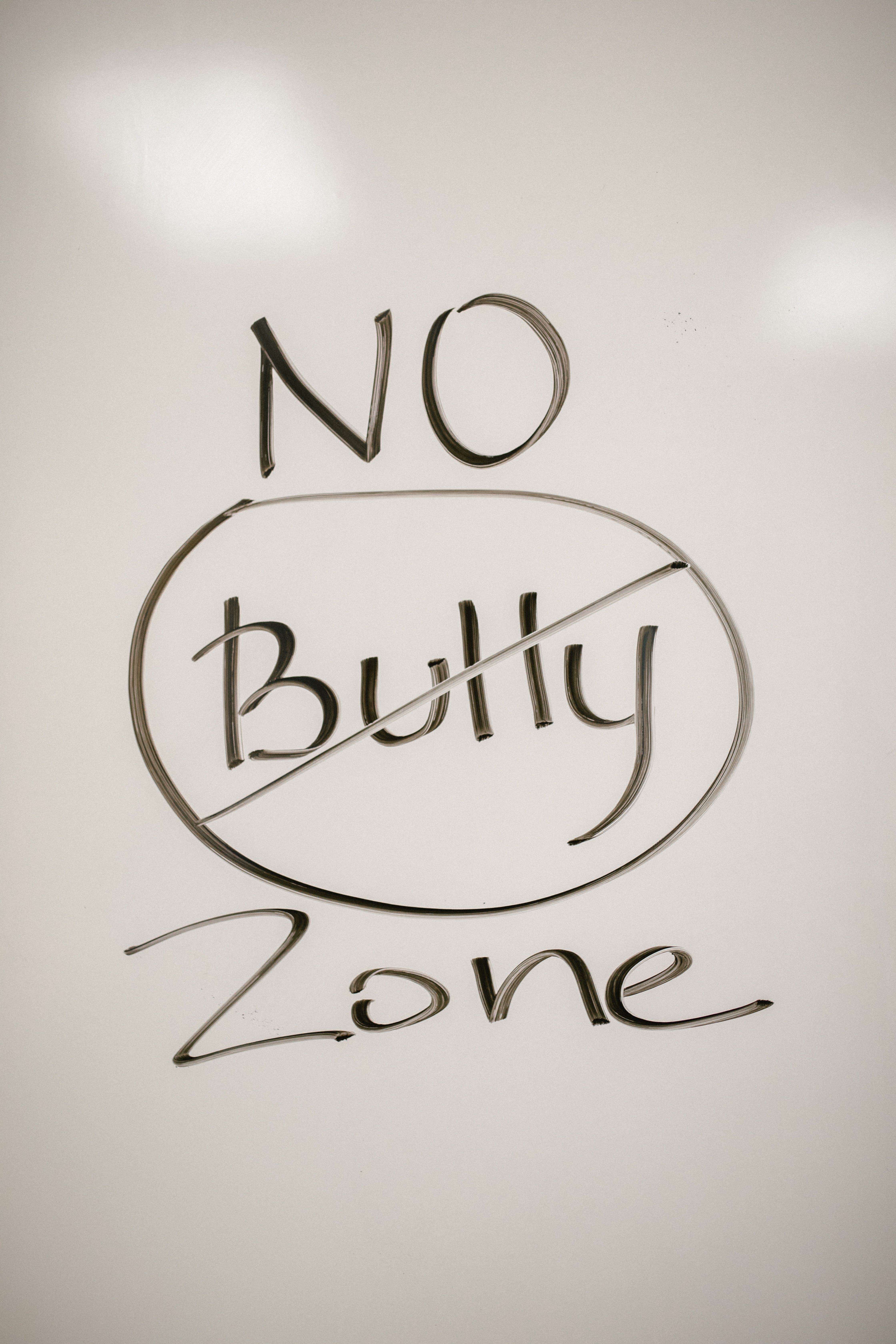 'No bully zone' on a whiteboard – the word 'bully' is crossed out with a circle around it.