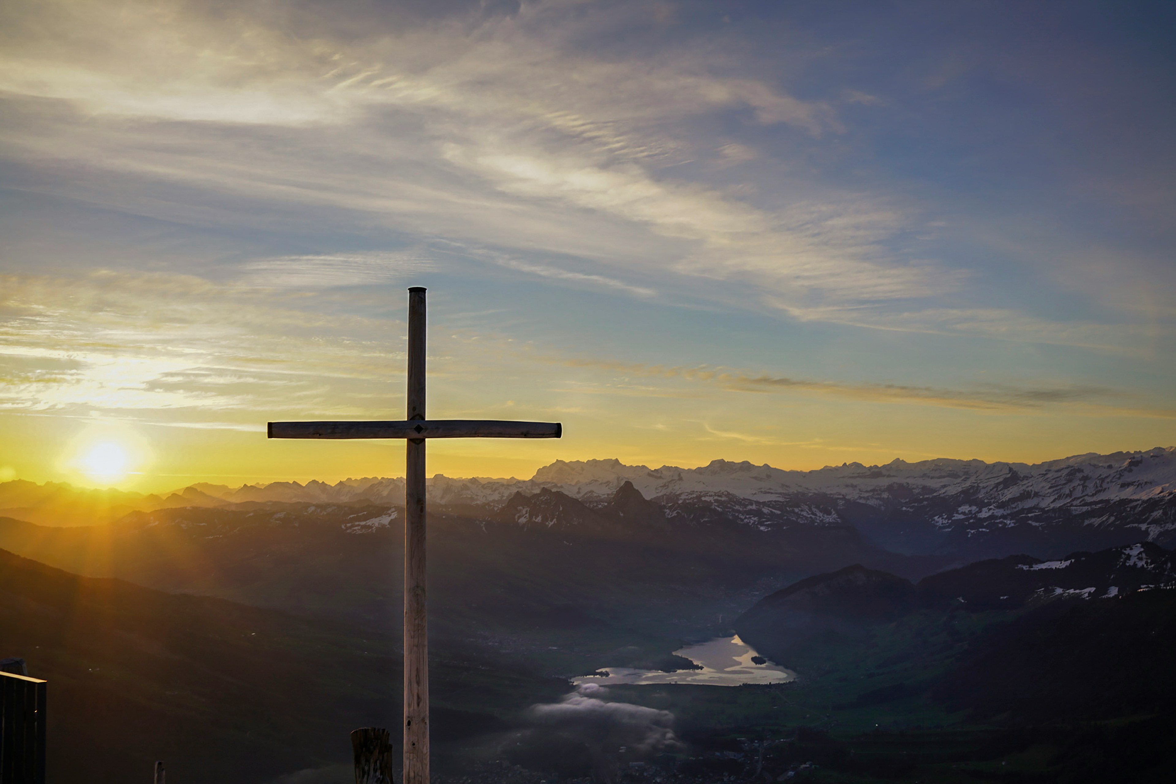 Christian cross in front of a sunset.