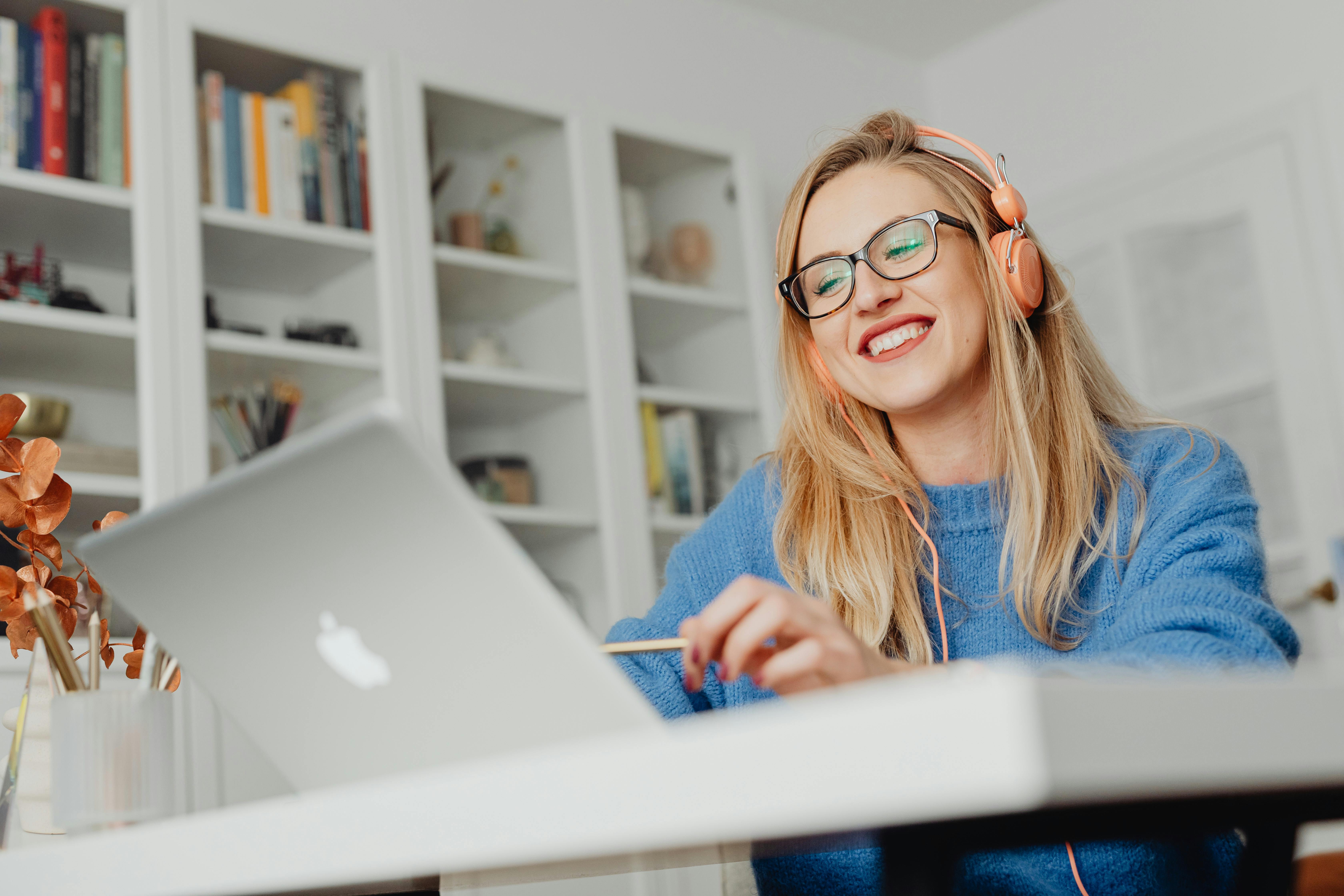 A woman smiling as she works on her laptop.