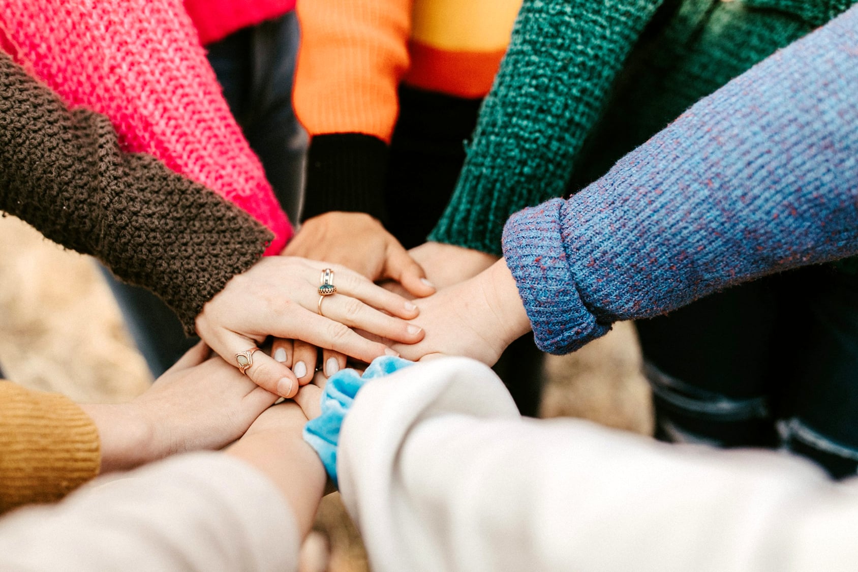 Hands coming together to form a circle.