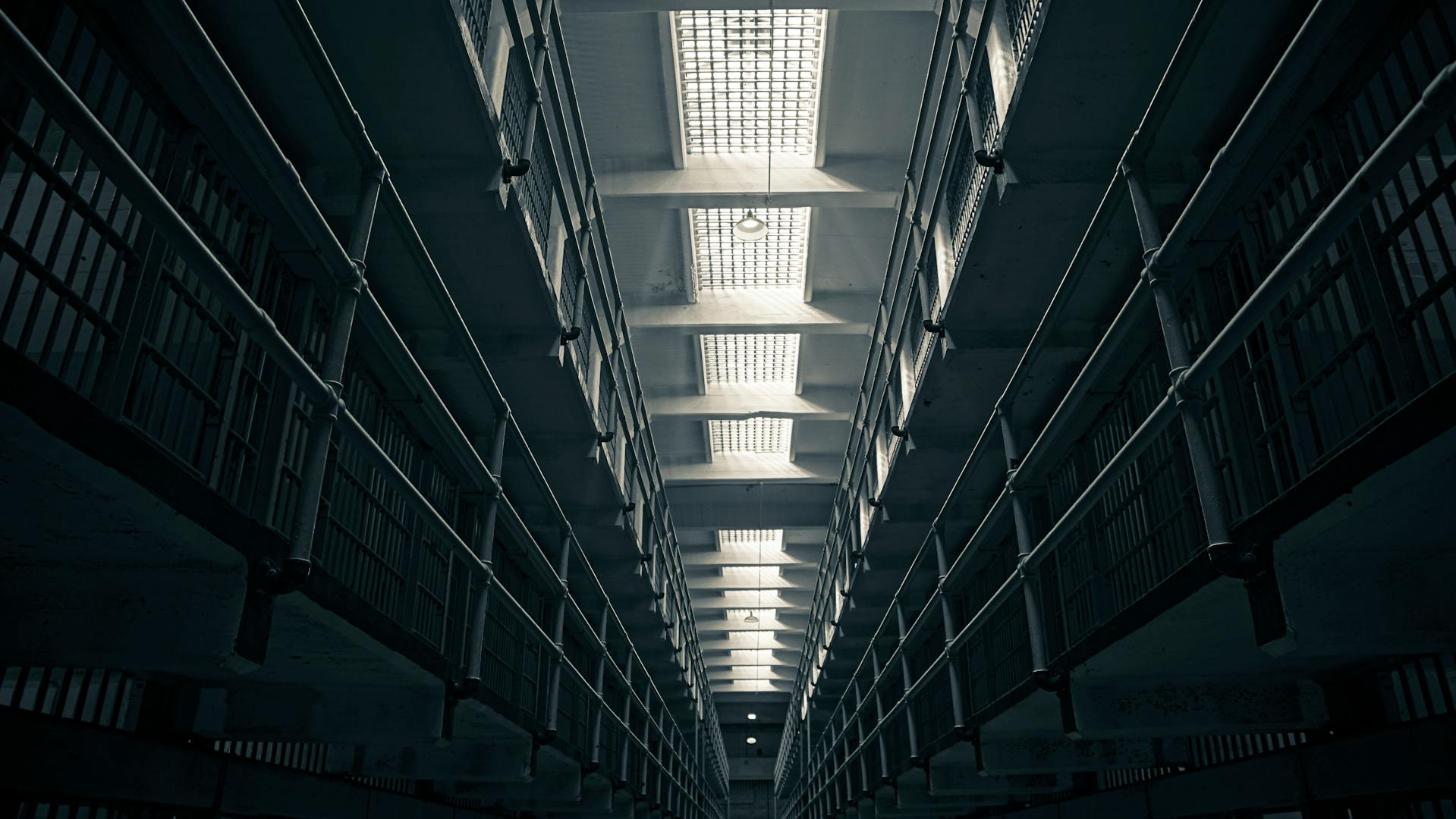 A black-and-white image of a prison corridor.