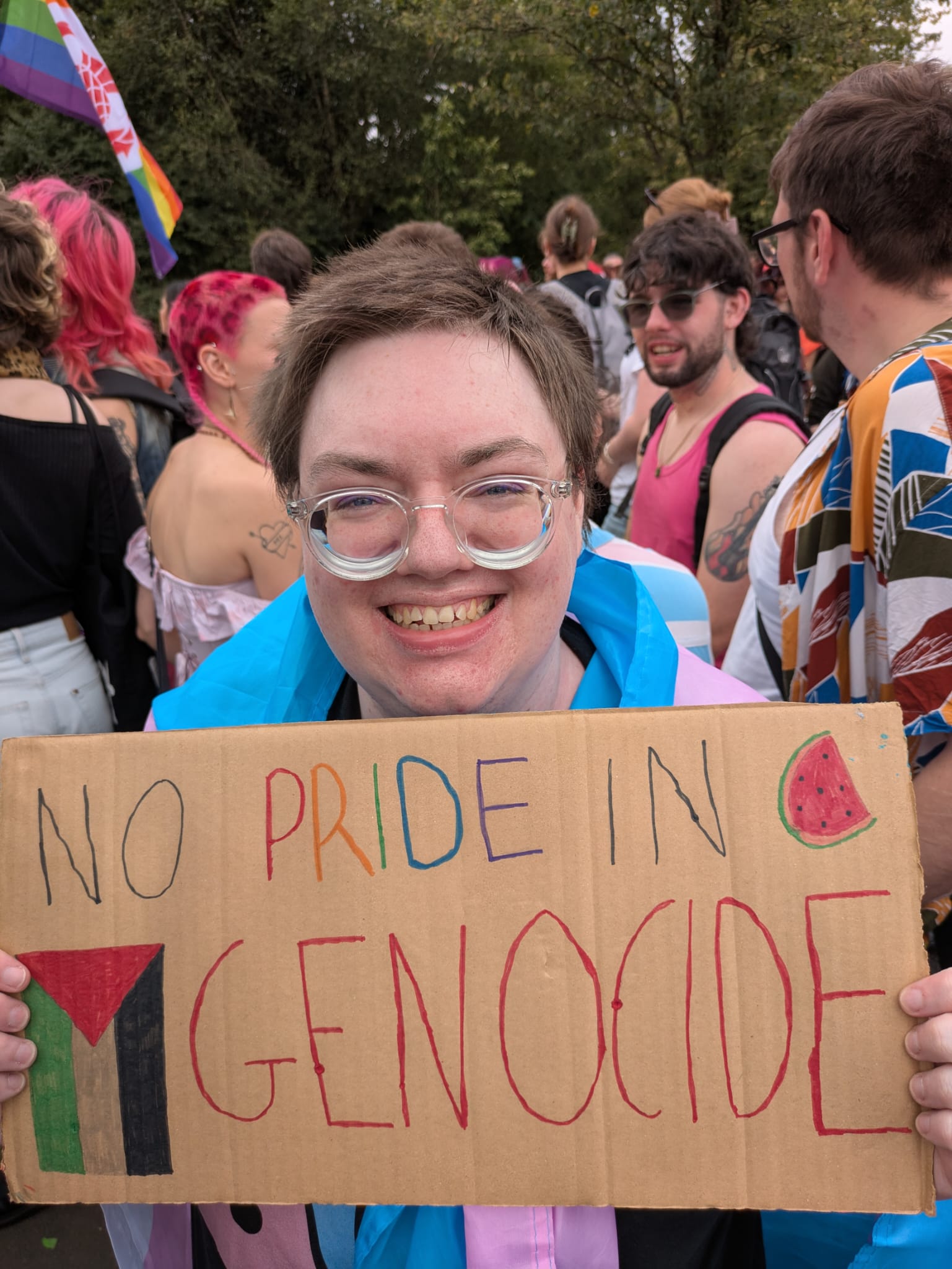 Kit Renard holding a sign saying 'No pride in genocide'.