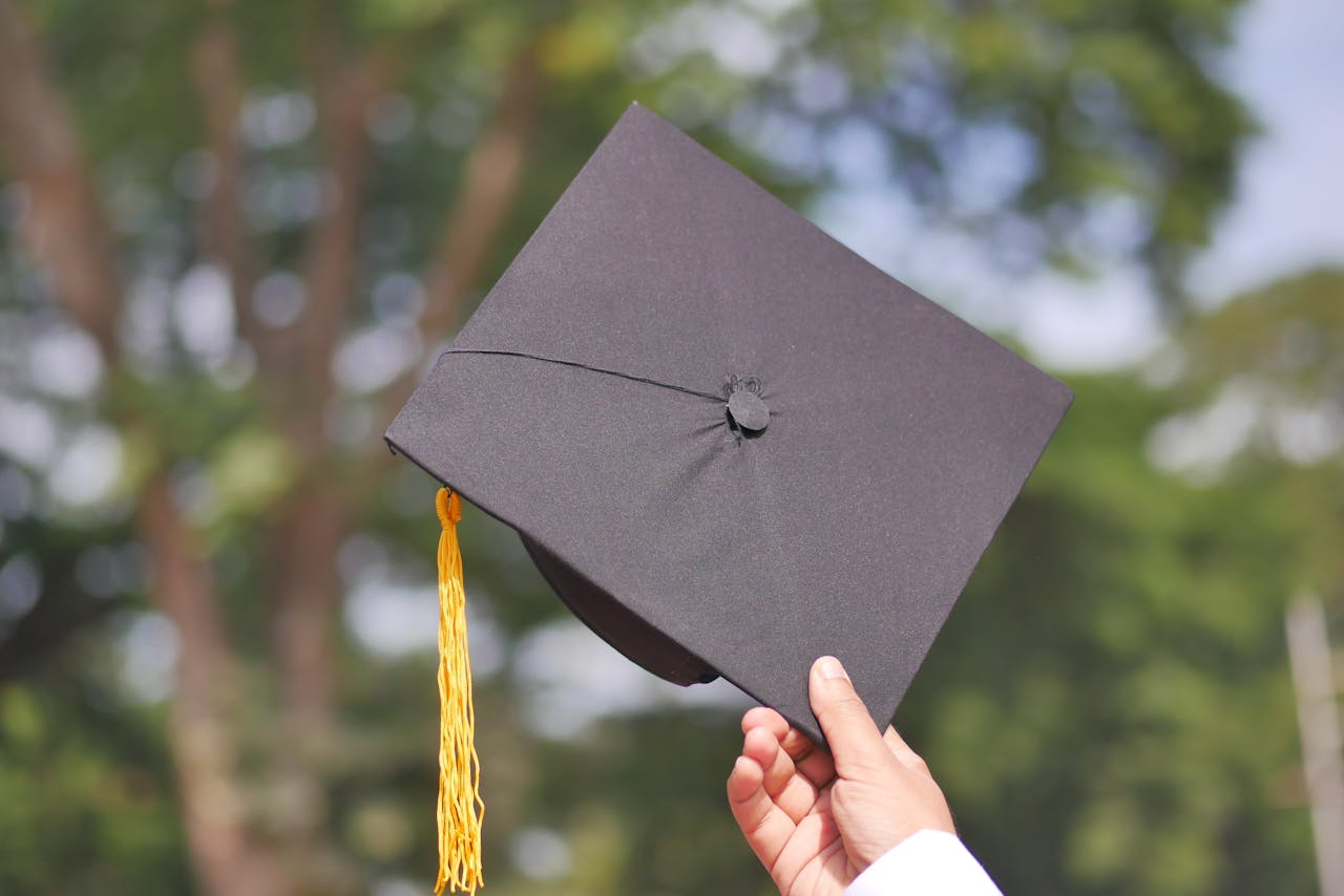 A graduation cap being held into the air.